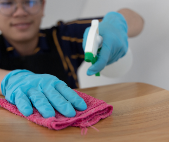 A man cleaning high part of the house